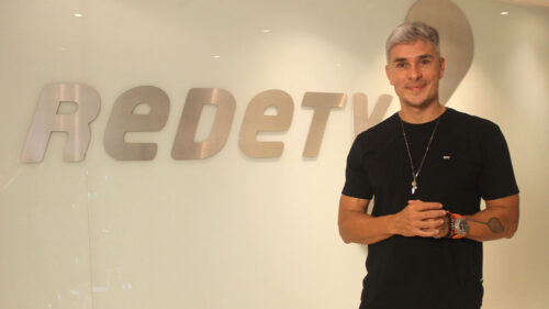 Ivan Moré em foto com o logo da RedeTV! ao fundo