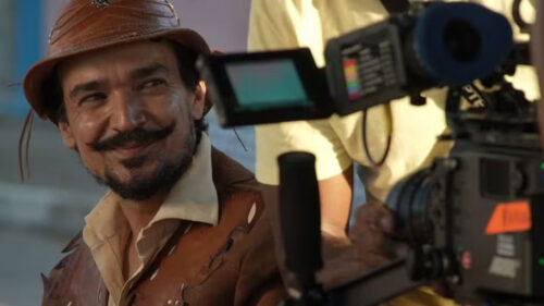 Tay Lopes durante gravações do filme O Sertão Vai Vir ao Mar, que está na programação de filmes da Globo, sorrindo em frente uma câmera