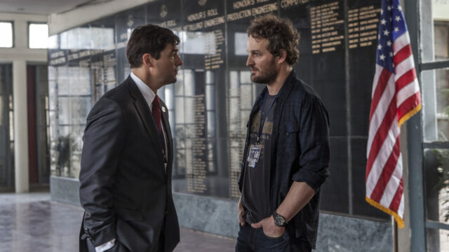 Kyle Chandler de terno conversando com Jason Clarke em cena do filme A Hora Mais Escura