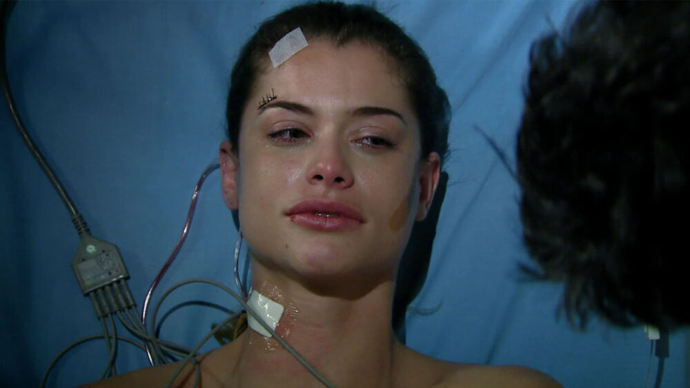 Alinne Moraes como Luciana deitada em cama de hospital em cena de Viver a Vida