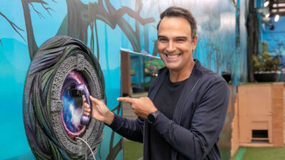 Apresentador do BBB 25, Tadeu Schmidt está sorridente segurando o Big Fone