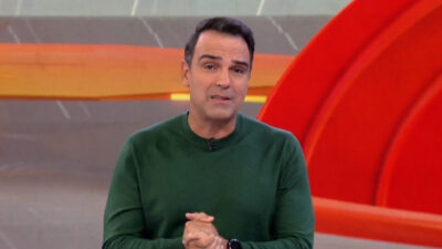 Tadeu Schmidt de camisa de manga longa da cor verde durante apresentação do BBB 25