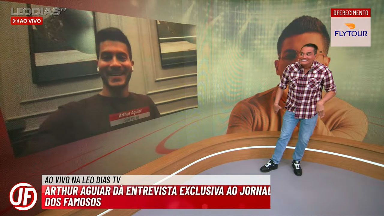 Arthur Aguiar participa de entrevista virtual no Jornal dos Famosos, apresentado por Leo Dias em um estúdio com painel digital