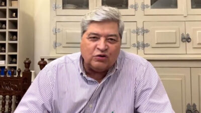 José Luiz Datena sentado em frente a um armário de cozinha enquanto fala durante uma transmissão
