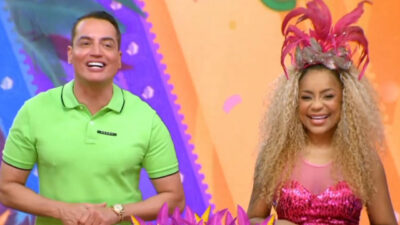 Leo Dias e Cariúcha na chamada do SBT Folia 2025, sorrindo em um cenário colorido com tema carnavalesco