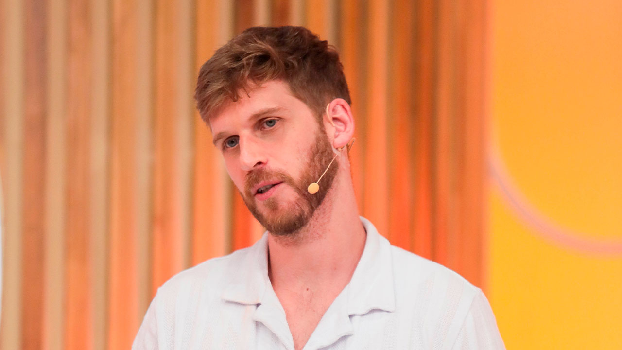 Paul Cabannes, usando camisa branca e microfone de lapela, fala durante sua participação no programa Sabadou com Virginia