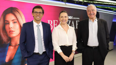 Rodolfo Schneider, Mônica Pimentel e João Saad, presidente do Grupo Bandeirantes, com imagem da novela Beleza Fatal em telão na sede da Band