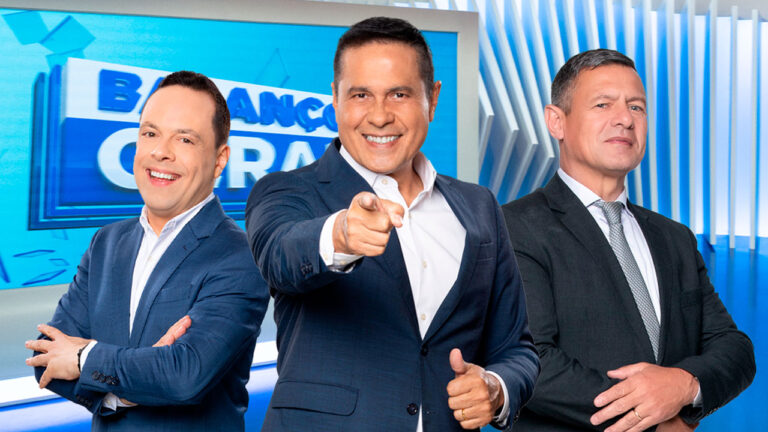 Thiago Gardinali, William Leite e Diógenes Lucca posam sorrindo no cenário do programa Balanço Geral, com fundo azul e branco