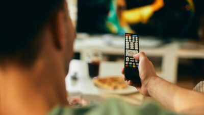 Imagem de homem segurando controle de TV