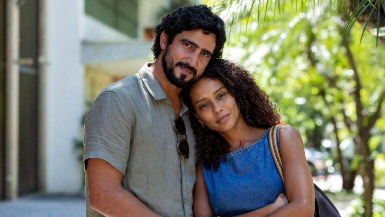 Renato Góes como Ivan e Taís Araújo como Raquel abraçados em foto do remake de Vale Tudo