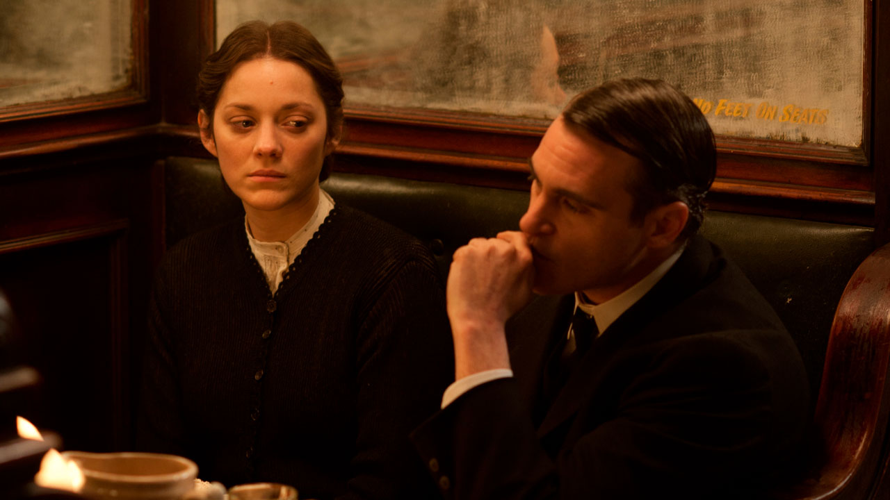 Marion Cotillard e Joaquin Phoenix sentados em restaurante em cena do filme Era Uma Vez em Nova York de 2013