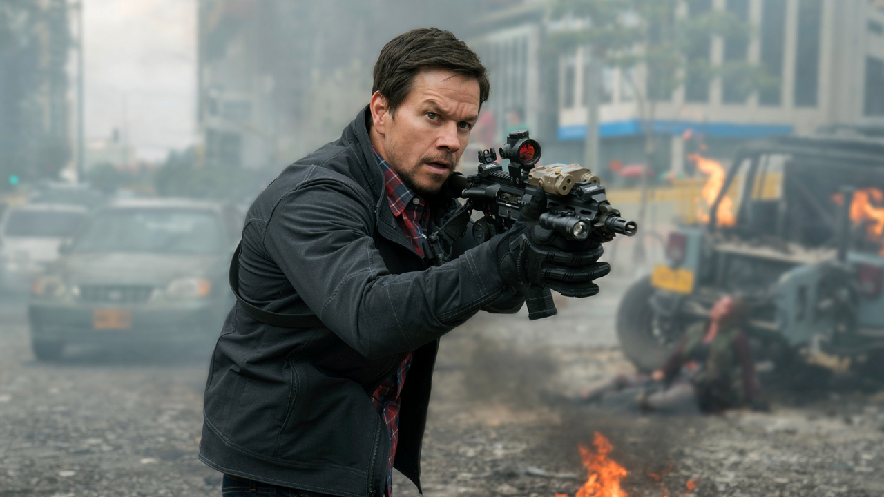 Mark Wahlberg segura um rifle tático em meio a um cenário urbano de destruição com carros em chamas no filme 22 Milhas (2018)