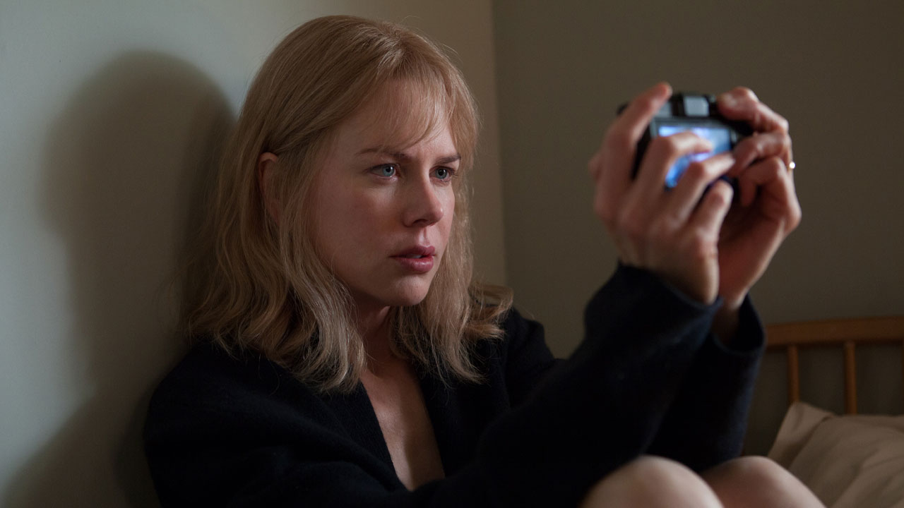 Nicole Kidman caracterizada como Christine no filme Antes de Dormir (2014), segurando uma câmera digital em um quarto com expressão séria