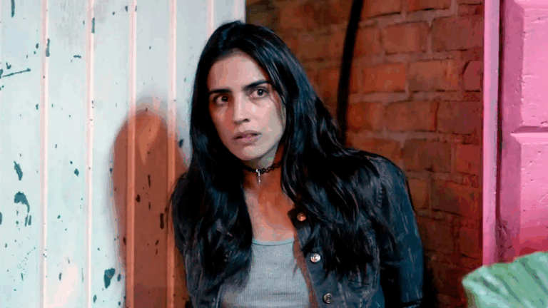 Bárbara de Regil caracterizada como Rosario Tijeras encostada em parede olhando assustada para frente