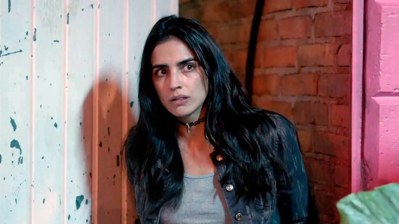 Bárbara de Regil caracterizada como Rosario Tijeras encostada em parede olhando assustada para frente