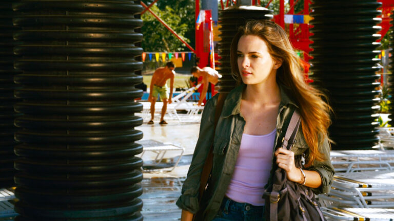 Maddy (Danielle Panabaker) caminha séria por parque aquático em cena de Piranha 2 (2012)