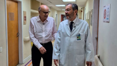 Drauzio Varella e Paulo Niemeyer Filho conversam em corredor de hospital durante gravação de série do Fantástico sobre doenças do cérebro