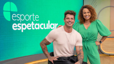Fernando Fernandes e Karine Alves sorrindo no estúdio do Esporte Espetacular com logo do programa ao fundo