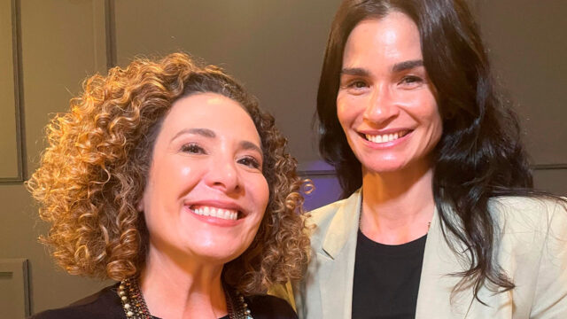 Giuliana Girardi e Carol Ribeiro sorrindo nos bastidores de reportagem do Fantástico na TV Globo