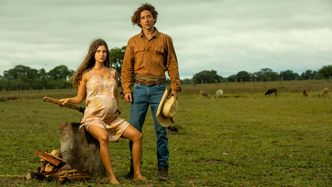 Juma (Alanis Guillen) grávida sentada ao lado de Jove (Jesuíta Barbosa) em cena rural de Pantanal (2022)