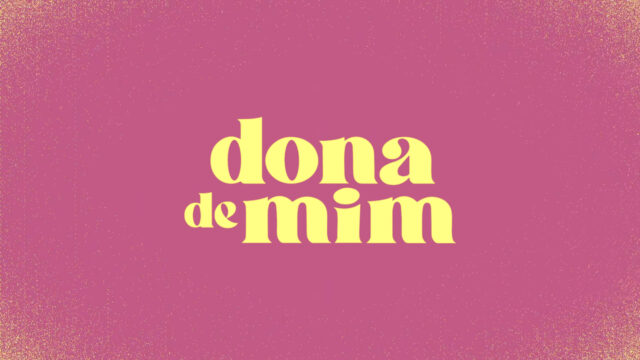 Logotipo da novela Dona de Mim com letras amarelas centralizadas sobre fundo rosa texturizado