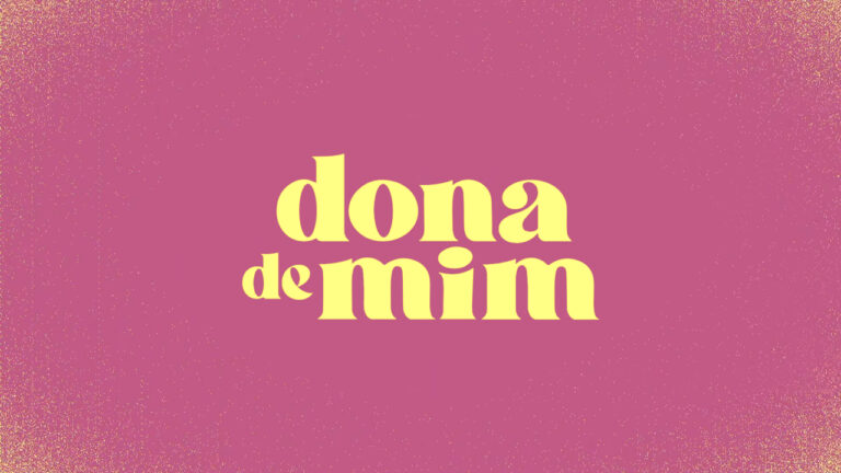 Logotipo da novela Dona de Mim com letras amarelas centralizadas sobre fundo rosa texturizado