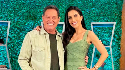 Luis Ricardo e Daniela Albuquerque posam juntos no cenário do programa Sensacional, com parede verde ao fundo