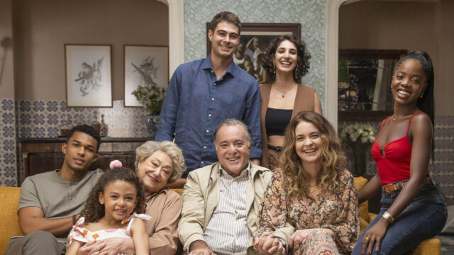 Elenco de Dona de Mim reunido na sala de casa em foto promocional da novela, sorrindo para a câmera
