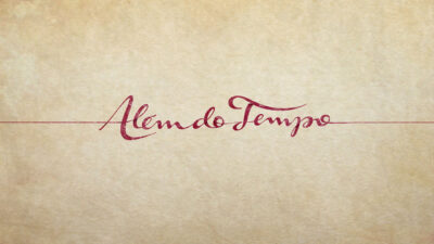 Logotipo da novela Além do Tempo em letras vermelhas sobre fundo bege texturizado, atravessado por linha horizontal
