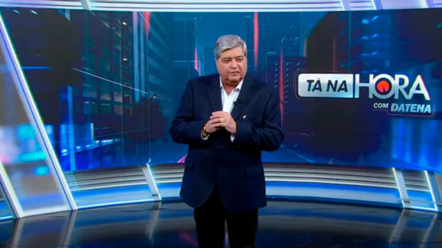 José Luiz Datena no cenário do Tá na Hora do SBT com logotipo do programa ao fundo