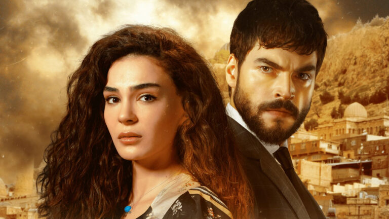 Ebru Sahin e Akin Akinozu em cena de Hercai com paisagem de cidade árida ao fundo