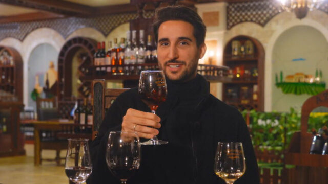 Murilo Salviano segurando taça de vinho em restaurante durante gravação do Globo Repórter no Azerbaijão
