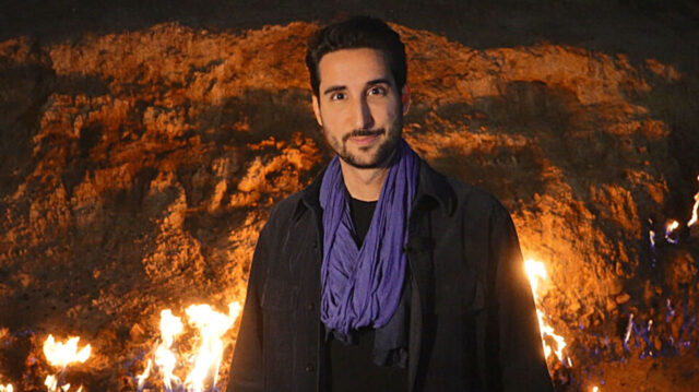 Murilo Salviano diante de chamas em encosta rochosa durante reportagem do Globo Repórter no Azerbaijão