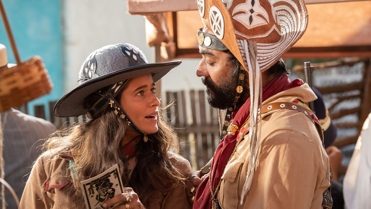 Rosa (Isadora Cruz) conversa com Josué (Tomás Aquino) usando trajes de cangaço em cena de Guerreiros do Sol