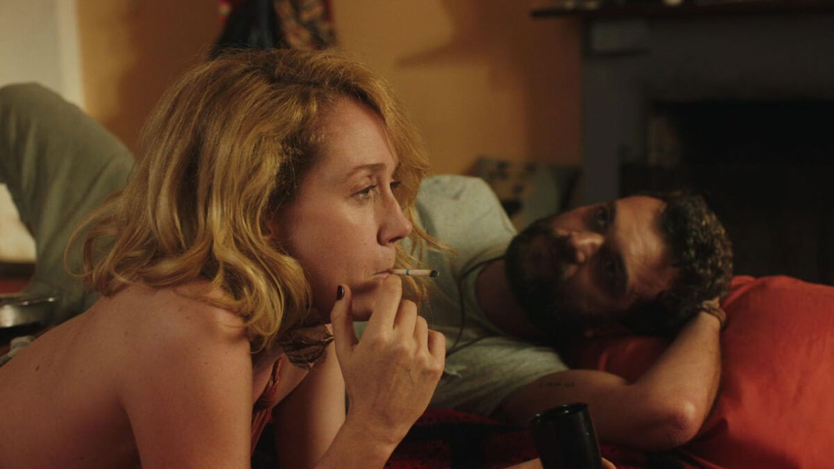 Camila Morgado fuma deitada ao lado de Ismael Caneppele em cena íntima do filme Domingo