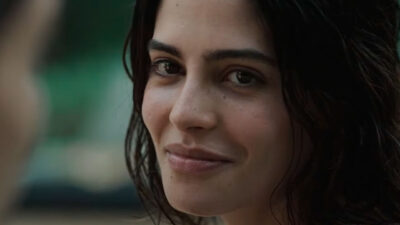 Julia Dalavia caracterizada como Clarice olhando séria para a câmera na série Dias Perfeitos