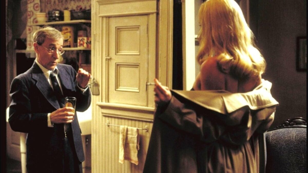 Woody Allen como CW Briggs encara Charlize Theron como Laura Kensington abrindo o sobretudo em O Escorpião de Jade (2001)