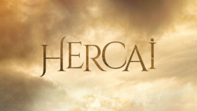 Logo da novela Hercai com letras douradas sobre fundo de céu com nuvens em tons quentes