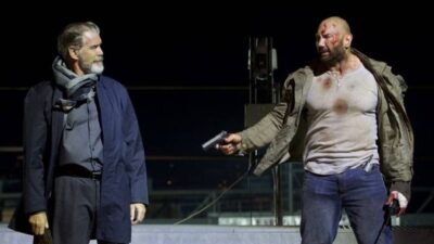 Dimitri (Pierce Brosnan) encara Knox (Dave Bautista) que aponta uma arma em cena de Refém do Jogo de 2018