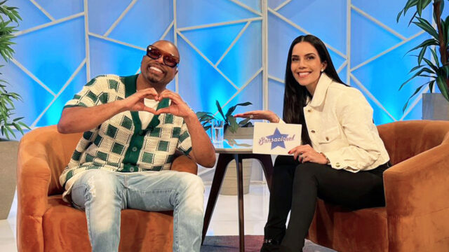 Buchecha faz gesto de coração com as mãos ao lado de Daniela Albuquerque no cenário do programa Sensacional