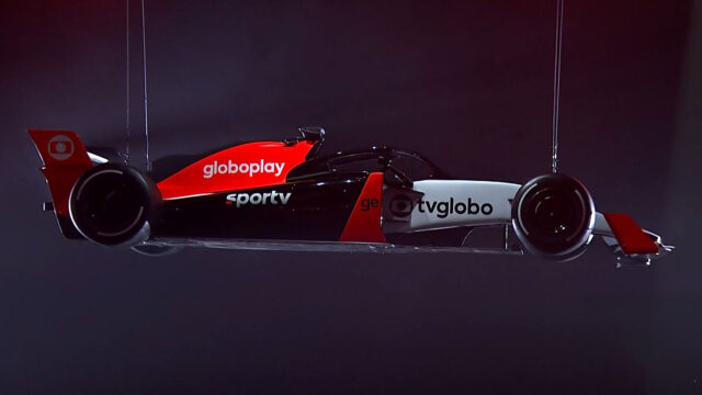 Carro de Fórmula 1 estilizado com logotipos da Globo, Globoplay, SporTV, ge e TV Globo pendurado em estúdio escuro