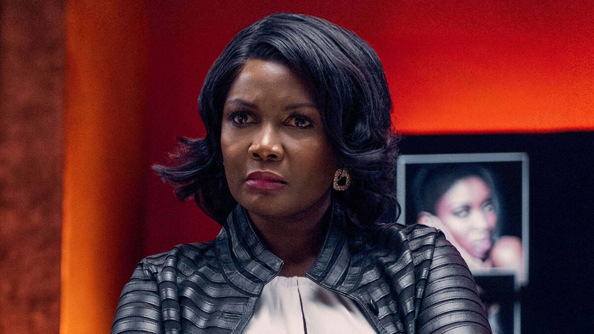 Sarah Niles caracterizada como Claudia com expressão séria em cena da série Ricos