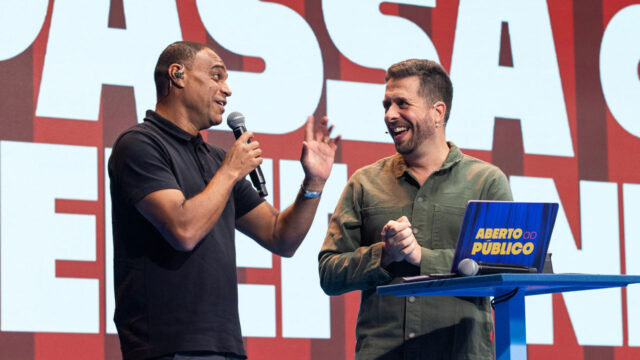 Denílson e Maurício Meirelles conversam sorrindo no palco do Aberto ao Público