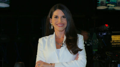 Fabi Saad sorrindo de braços cruzados nos bastidores do programa Mulheres Positivas da Record News