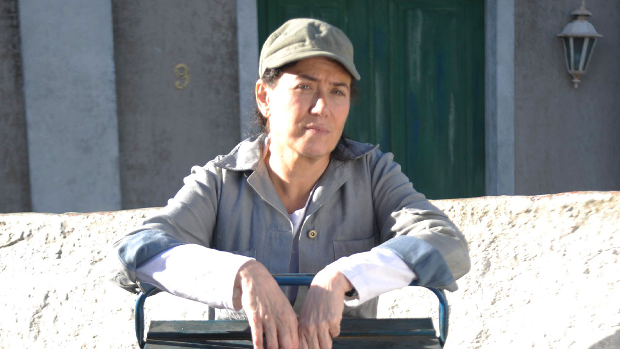 Lilia Cabral caracterizada como Griselda em cena da novela Fina Estampa na fachada da casa 9