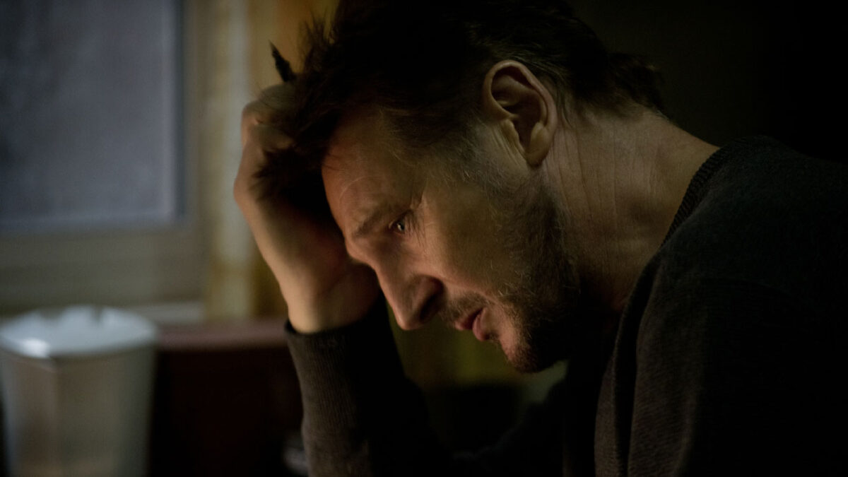 Liam Neeson caracterizado como Ottway sentado com expressão pensativa em cena do filme A Perseguição de 2011