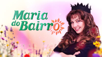 Thalia sorrindo com coroa preta ao lado do logo da novela Maria do Bairro entre flores coloridas