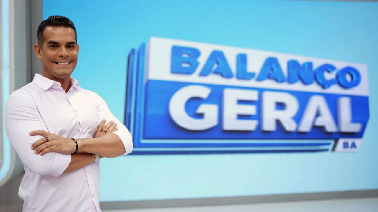 Marcos Pimenta de braços cruzados em frente ao telão do Balanço Geral BA no estúdio da Record