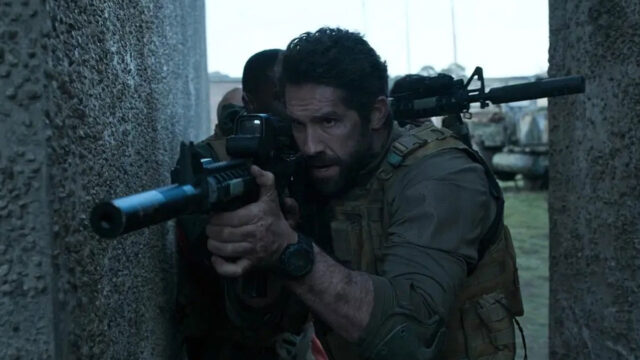 Jake Harris (Scott Adkins) armado e em posição de ataque entre paredes de concreto em cena do filme Tiro Certo