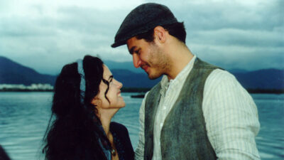 Juliana (Ana Paula Arósio) e Matteo (Thiago Lacerda) trocam olhares sorridentes à beira-mar em cena de Terra Nostra